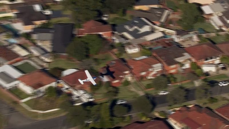  Small plane loses power and skims suburban rooftops before making crash landing on belly